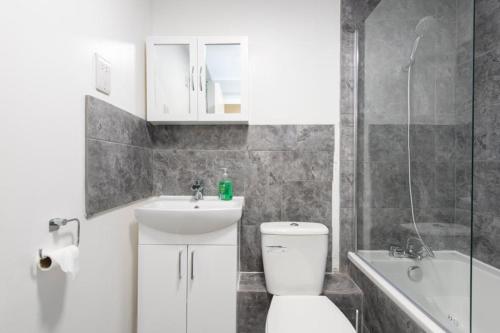 ein Badezimmer mit einem WC, einem Waschbecken und einer Badewanne in der Unterkunft Modern 2 bed apartment 4 separate beds in Thamesmead in Thamesmead
