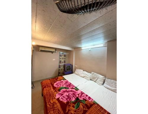 - une chambre avec un lit orné de fleurs roses dans l'établissement Hotel Forever, Ujjain, à Ujjain