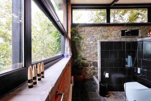 a bathroom with a large window and a stone wall at Brickyard Retreat at Mutianyu Great Wall Adjoin to Mutianyu Great Wall - Room with the View of Great Wall - Chinese massage experience - Vehicle Shuttle Service - International Catering - SPA& Nail Beauty Facilities in Huairou