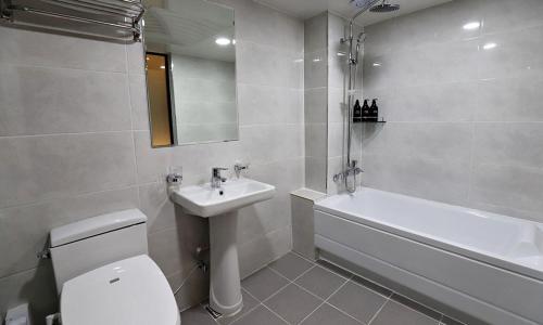 a bathroom with a toilet and a sink and a bath tub at Incheon Illuwa Hotel in Incheon