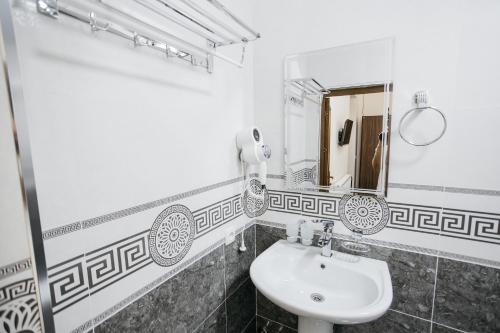 ein Bad mit einem Waschbecken und einem Spiegel in der Unterkunft Nazarxan Hotel in Samarkand