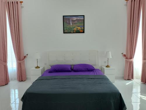 1 dormitorio con cama morada y cortinas rosas en Homestay Villa Muslim Kuala Terengganu with pool and parking, en Kuala Terengganu