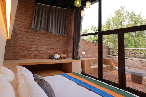 a living room with a couch and a large window at Brickyard Retreat at Mutianyu Great Wall Adjoin to Mutianyu Great Wall - Room with the View of Great Wall - Chinese massage experience - Vehicle Shuttle Service - International Catering - SPA& Nail Beauty Facilities in Huairou