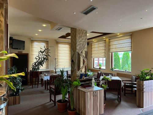 ein Restaurant mit Tischen, Stühlen und Pflanzen in der Unterkunft Hotel Dva Goluba in Pale