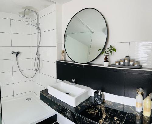 a white bathroom with a sink and a mirror at Ferienhaus Doina in Gehlberg