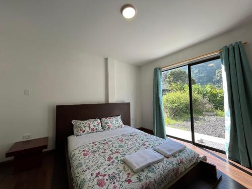 a bedroom with a bed and a large window at Brand new Holiday Villa - 3 bedroom 4 bathroom in Baños