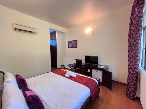 a bedroom with a bed and a desk with a computer at ēRYA by SURIA Janda Baik in Bentong