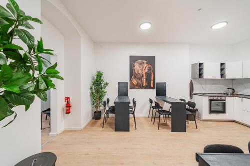 a room with tables and chairs and a painting on the wall at Chic Central City Rooms by Home2 in Vienna