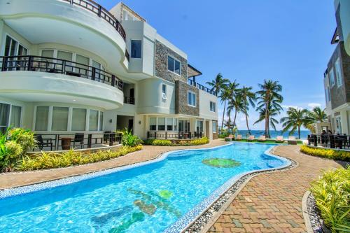 a house with a swimming pool in front of the ocean at 7Stones Boracay in Boracay