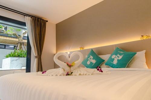 a bedroom with a bed with a heart decoration on it at Tour De Phuket Hotel - SHA Plus in Thalang