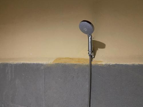 a shower head on top of a concrete ledge at RedDoorz near Gedung Kesenian Palopo in Palopo