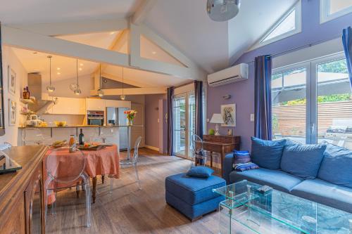 un salon avec un canapé bleu et une cuisine dans l'établissement Maison Le Moulleau, à Arcachon