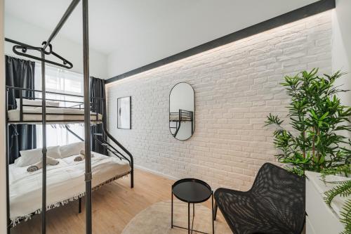 sypialnia na poddaszu z ceglaną ścianą i łóżkami piętrowymi w obiekcie Chic Central City Rooms by Home2 w Wiedniu