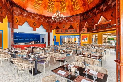 a restaurant with tables and chairs and a large ceiling at Pickalbatros Jungle Aqua Park - Neverland Hurghada in Hurghada