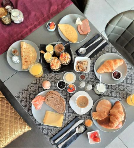 a table with plates of breakfast foods on it at Abalona Hotel & Apartments in Dendermonde