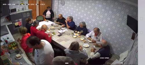 a group of people sitting around a table eating food at Pensión Casa do Gallo Sarria in Sarria