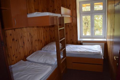 two bunk beds in a room with a window at Zámeček nad Běleckým Mlýnem 