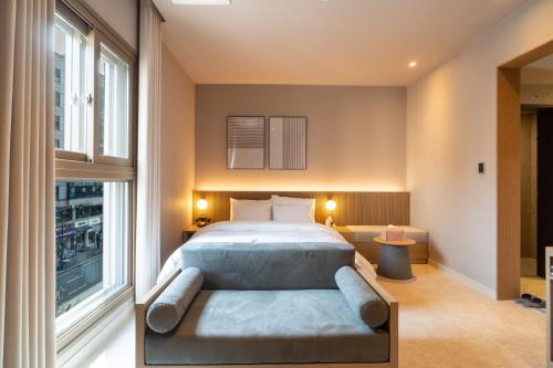 Goyang Hotel Yuji في غويانغ: غرفة نوم بسرير ونافذة كبيرة