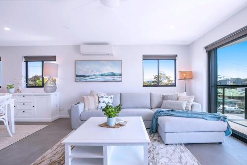 a living room with a couch and a table at HOT Stylish Costal 3 ensuite apartment on Redcliffe, Brisbane in Redcliffe