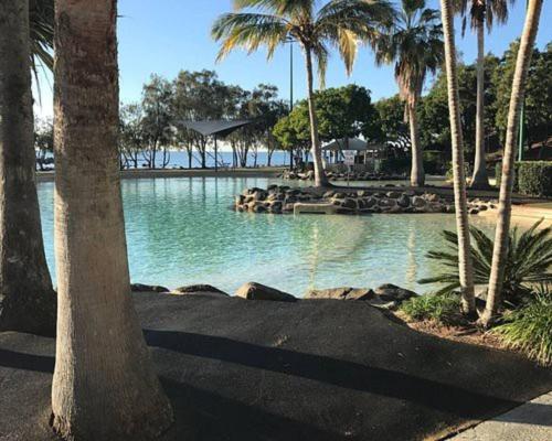 a pool of water with palm trees and a beach at HOT Stylish Costal 3 ensuite apartment on Redcliffe, Brisbane in Redcliffe