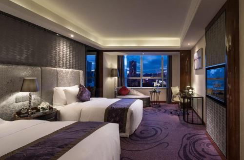 um quarto de hotel com duas camas e uma janela em Sentosa Hotel Shenzhen Feicui Branch, Enjoy tropical swimming pools and high-class fitness club em Shenzhen