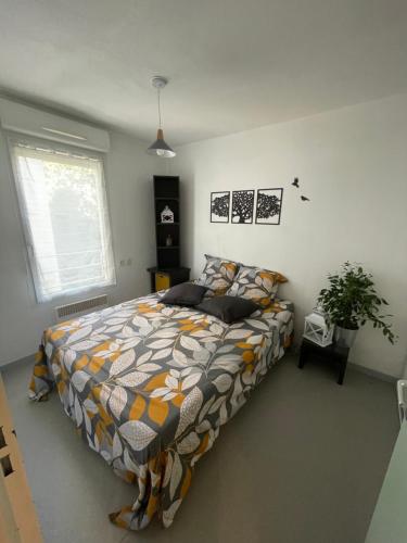 a bedroom with a bed with a colorful comforter at Cosy arena in Nîmes