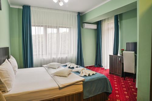 a bedroom with a large bed with a window at Hotel Abi in Baile Felix