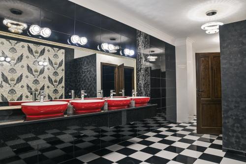 a bathroom with a row of red sinks and mirrors at Hotel Abi in Baile Felix