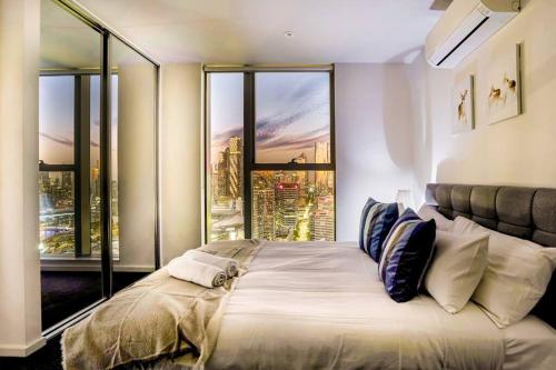 1 dormitorio con 1 cama grande y ventana grande en Sub-Penthouse 3B2B2Carpark City-Harbor View, en Melbourne