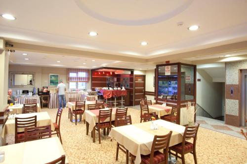 a restaurant with tables and chairs and a tv at Sefa Hotel 2 Çorlu in Corlu