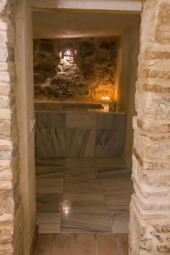 a stone hallway with a stone wall and a fireplace at AIRE RURAL JIMENA in Jimena de la Frontera
