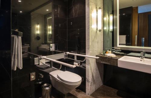 a bathroom with a toilet and a sink and a mirror at Hilton Istanbul Bomonti in Istanbul
