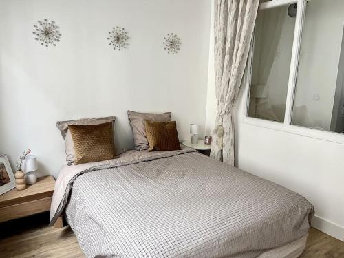 a bedroom with a bed and a large window at Le Huitième - Proche centre ville in Compiègne
