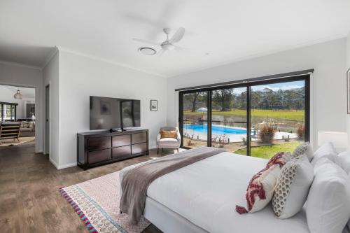 a bedroom with a bed and a view of a pool at Koala Lane in Bonville