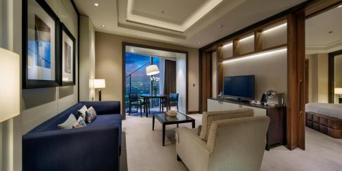 a living room with a blue couch and a bedroom at Hilton Istanbul Bomonti in Istanbul