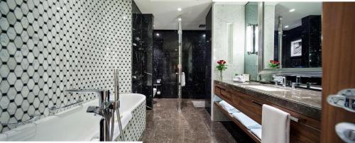 a bathroom with a tub and two sinks and a shower at Hilton Istanbul Bomonti in Istanbul