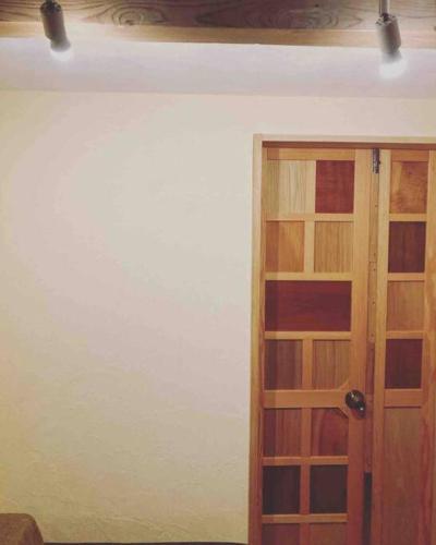 a room with a wooden door and a wall at 自然素材でリノベした木の香り漂う貸切宿｜藤野民宿（Fujino Guest House） in Fujino