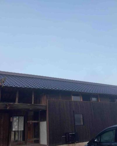 a building with a car parked in front of it at 自然素材でリノベした木の香り漂う貸切宿｜藤野民宿（Fujino Guest House） in Fujino