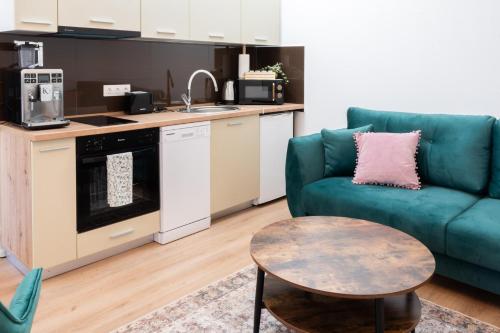 a living room with a blue couch and a table at Cris Apartments in Târgu-Mureş