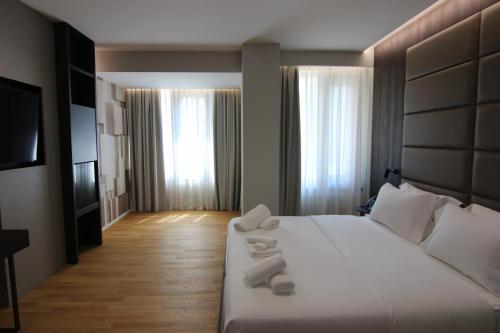 um quarto de hotel com uma cama com toalhas em Boutique Hotel Adelar em Tirana