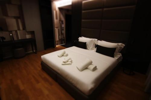 a bedroom with a bed with white sheets and pillows at Boutique Hotel Adelar in Tirana