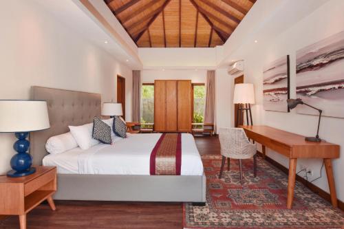 a bedroom with a bed and a desk at Moritz Palm Villa in Uluwatu