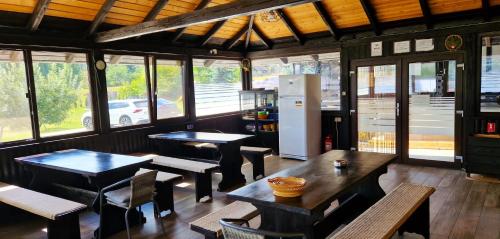 a restaurant with tables and chairs and a refrigerator at Bukovina Blue in Mănăstirea Humorului