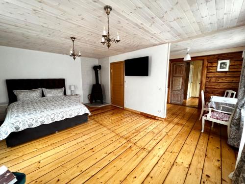 Schlafzimmer mit einem Bett und Holzboden in der Unterkunft Juveliera apartamenti in Kuldīga
