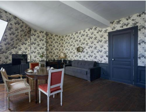 un salon avec une table et un canapé dans l'établissement Château du Prieuré Évecquemont, à Évecquemont