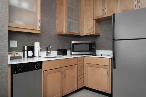 a kitchen with wooden cabinets and a white refrigerator at Residence Inn Birmingham Hoover in Hoover