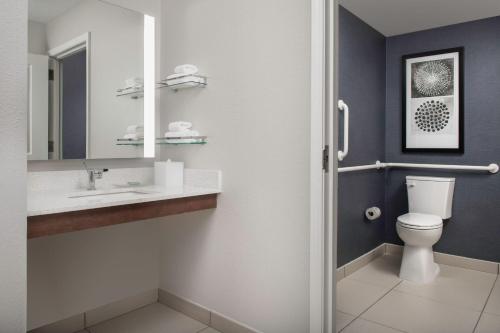 a bathroom with a toilet and a sink and a mirror at Residence Inn Birmingham Hoover in Hoover