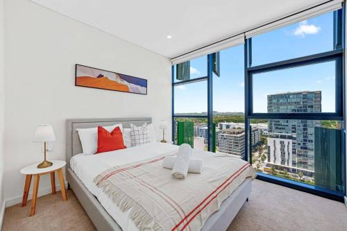 a bedroom with a bed and a large window at City View 2 Bedrooms apt in Waterloo in Sydney
