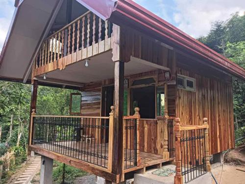 a large wooden house with a large deck at Little Cabins at Km 499 