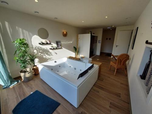 Habitación con baño con bañera blanca grande. en Hotel Restaurant The Kings Head Inn en Voeren